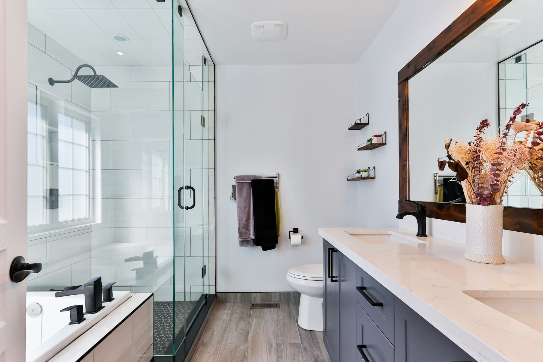 Bright bathroom with a vanity, toilet, and glass shower
