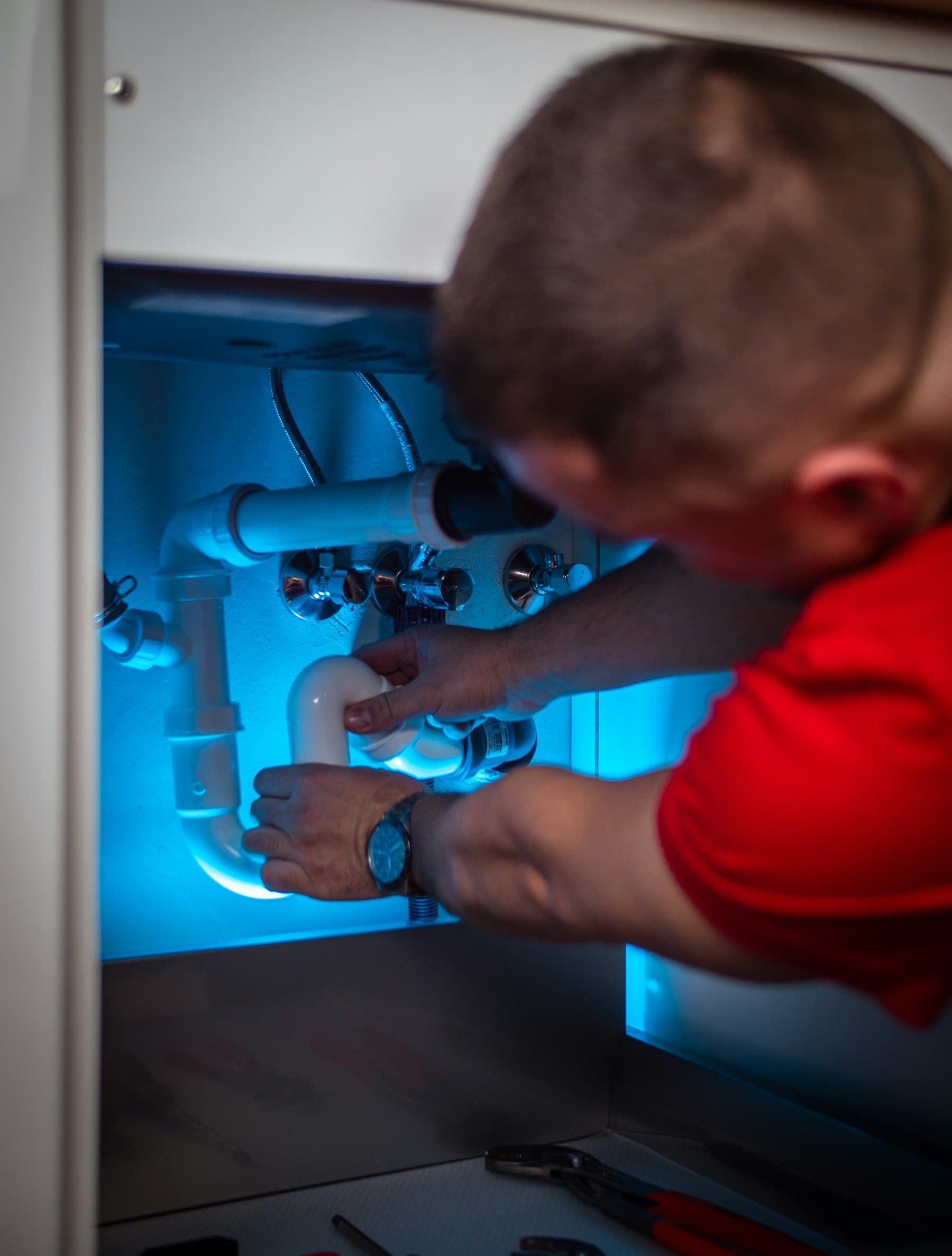 Plumber fitting a drain trap under a sink